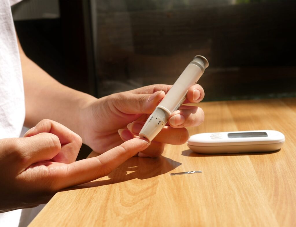 Person monitoring blood sugar levels using a continuous glucose monitor and smartphone