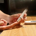 Person monitoring blood sugar levels using a continuous glucose monitor and smartphone